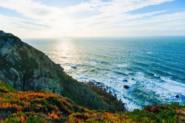 büyük taşlar ve deniz suyu eteklerinde yüksek kayalık sahil 