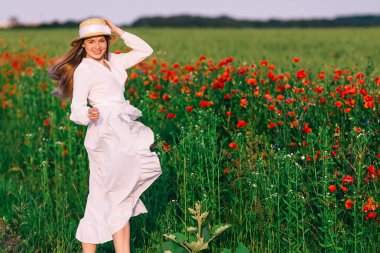 Beyaz elbiseli güzel kız kameraya bakar ve gülümser.