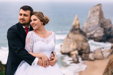 Damat geline arkadan sarılıyor ve gülümsüyor. okyanus