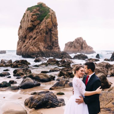 Kıyıya yakın okyanusta yüksek sarp kayalıklar ve bir sürü taş. h