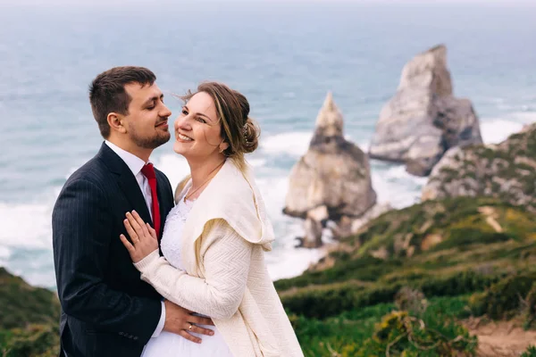 Takım elbiseli damat, gelinini düğün elbisesinde öper.