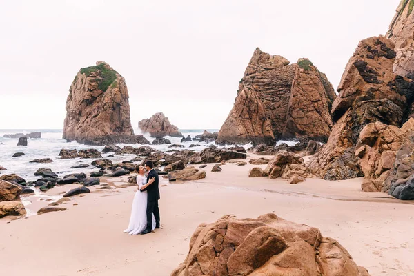 Yüksek ve dik kayalıkları olan okyanus kumlu sahil. Her biri yeni evliler. — Stok fotoğraf