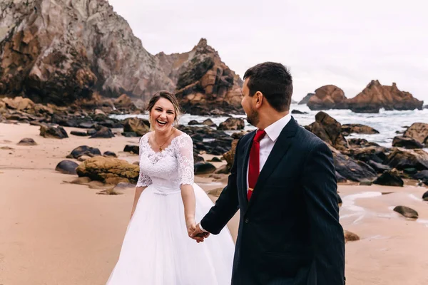 Gelin ve damat el ele tutuşup gülümsüyor. Yeni evliler... — Stok fotoğraf