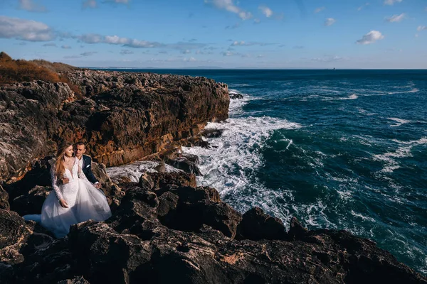 Recém-casados na costa rochosa do oceano. oceano azul sem fim. — Fotografia de Stock