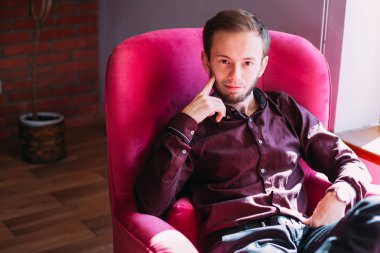 Şık kıyafetler giyen çekici bir adamın portresi.