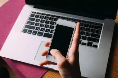 Bilgisayarın arka planında cep telefonu olan bir el kamerası.