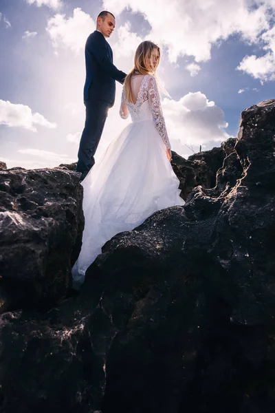 O noivo segura a noiva pela mão e olha para ela. recém-casados — Fotografia de Stock