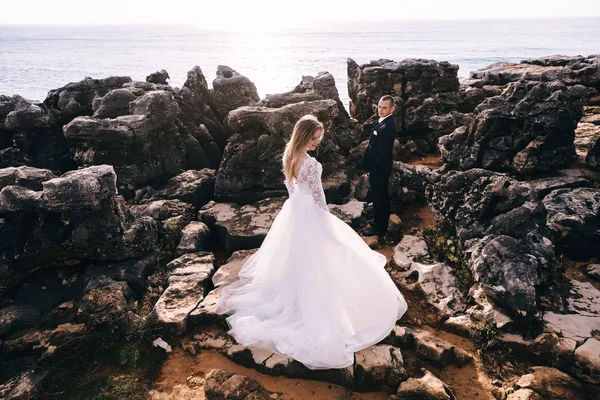 Brudgummen i kostymen tittar på bruden i vit klänning. stora r in — Stockfoto