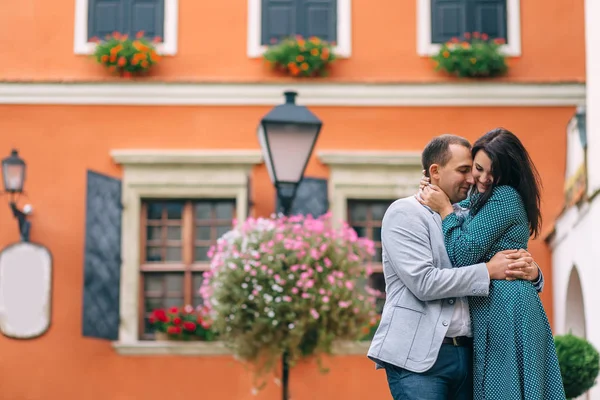 Пара влюбленных обнимается на заднем плане здания. оранжевый — стоковое фото