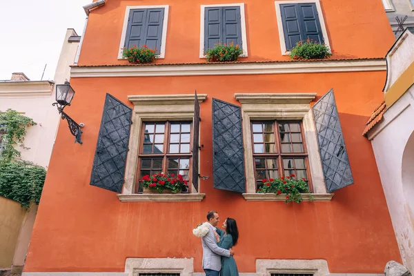 Закохана пара на помаранчевому будівельному фоні. дівчина тримає бут — стокове фото