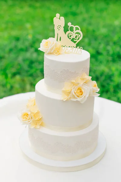 Pastel de boda decorado con flores y una figura de los recién casados — Foto de Stock