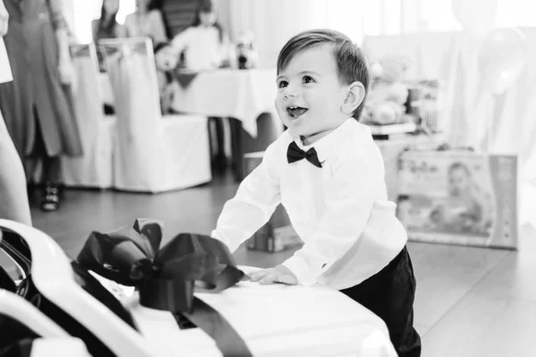 Kleine jongen in stijlvolle kleren glimlachend en staande in de buurt van de auto — Stockfoto