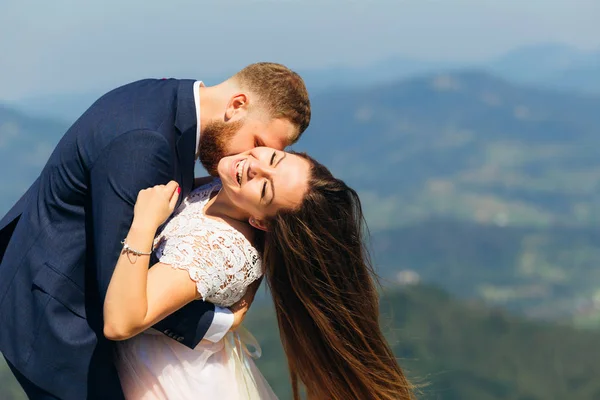 Damat gelini boynundan öper ve belini tutar. — Stok fotoğraf