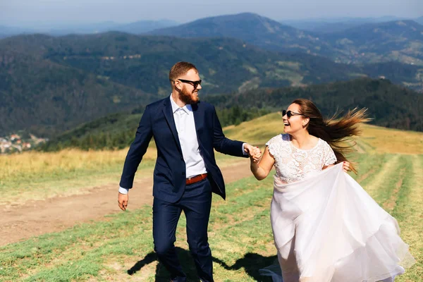 Recém-casados sinceramente sorrir e olhar uns para os outros no topo da t — Fotografia de Stock