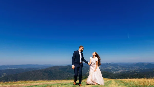 Recém-casados desfrutar uns dos outros e caminhar no topo da montanha w — Fotografia de Stock