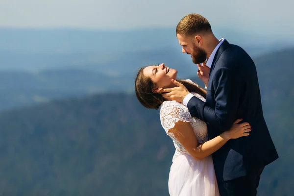 La sposa sorride sinceramente e chiude gli occhi e abbraccia la g — Foto Stock