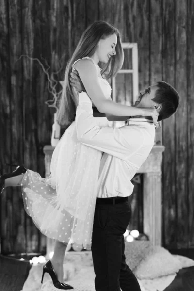 The guy picking up the girl and they look at each other on black — Stock Photo, Image