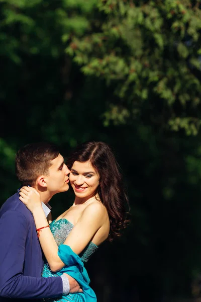 Adam bir kıza sarılıyor ve onu öpmek istiyor. Ayrıca bir erkeğe sarılıyor. — Stok fotoğraf
