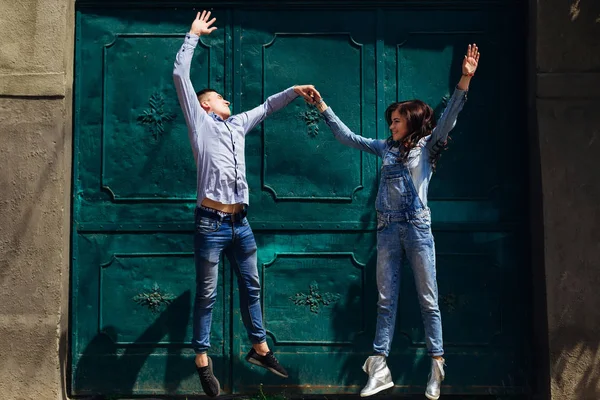 Αγόρι και κορίτσι κρατήστε τα χέρια και άλμα κοντά στην όμορφη πόρτα σε ένα su — Φωτογραφία Αρχείου
