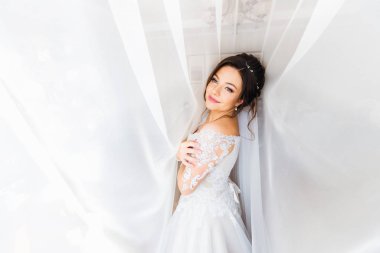 Beyaz elbiseli güzel gelin kameraya bak ve gülümse.