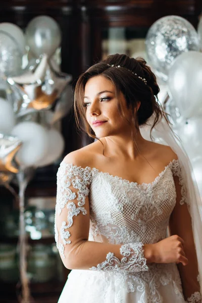 Menina bonita em um vestido de noiva no fundo do quarto com — Fotografia de Stock