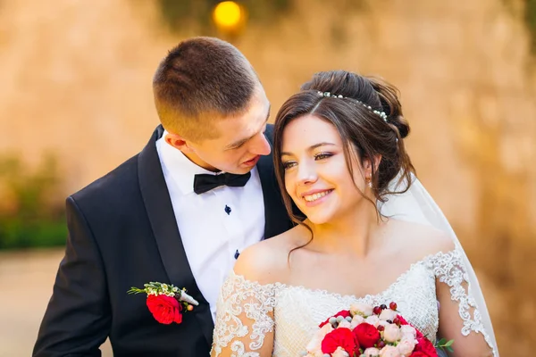 Um close-up de recém-casados felizes. a noiva sorri e mantém um casamento — Fotografia de Stock