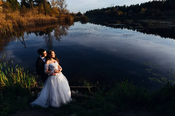 The groom embraces the bride from the back side. beautiful lake. — 스톡 사진