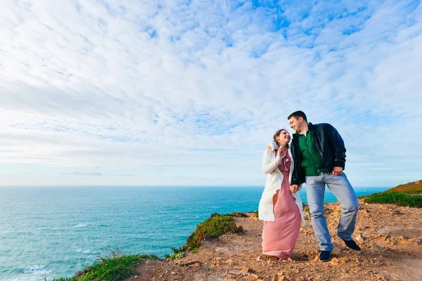 Lycklig man och hustru håller hand på stranden med en magnifik — Stockfoto