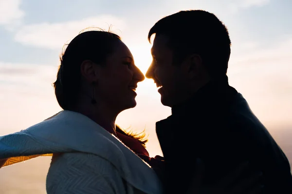 Gün batımında romantik çiftlerin silueti birbirlerine bakıyorlar. — Stok fotoğraf