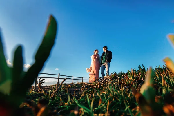 Grünes Gras im Vordergrund. das verliebte Paar schaut einander an o — Stockfoto