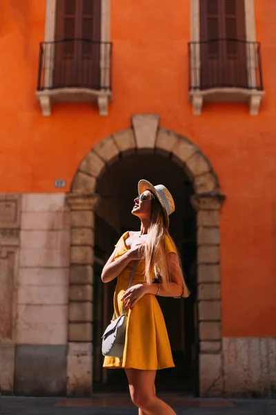 Девушка стоит напротив арки здания и позирует в y — стоковое фото