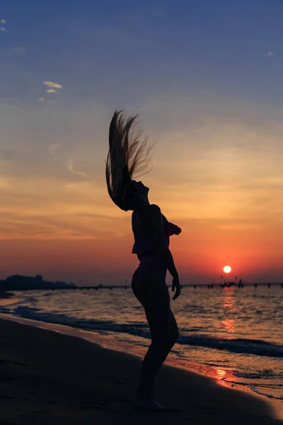 Pembe bir mayo kız saçını sahilde dalgalar. Deniz ve — Stok fotoğraf