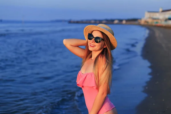 Young happy woman in pink swimwear, and sunglasses and boater. S — 스톡 사진