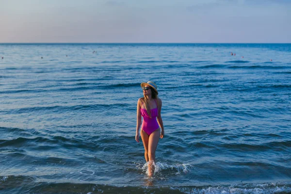 Jovem mulher em pé junto ao mar. Férias de verão. menina em nado rosa — Fotografia de Stock