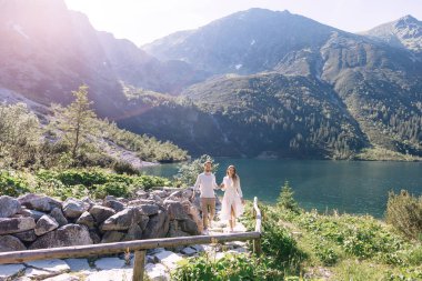 Erkek ve kız el ele tutuşuyorlar. Birbirine aşık çiftler. dağ