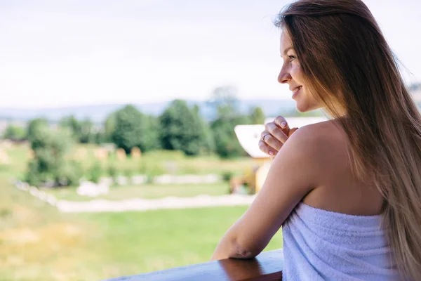 Perfil de uma menina com cabelos longos em uma toalha branca admirando o v — Fotografia de Stock