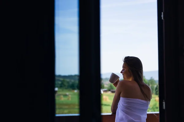 Wanita dengan handuk putih dengan secangkir kopi di pagi hari. belakang v — Stok Foto