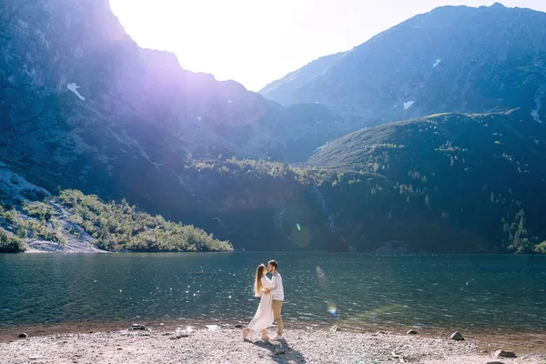 Verliebtes Paar küsst sich am See. schöne Berge bedeckt — Stockfoto