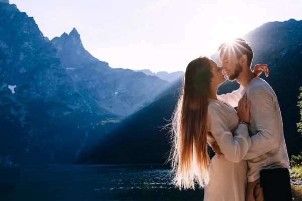 The guy hugs the girl in a white dress for her waist and they cl — Stock Photo, Image