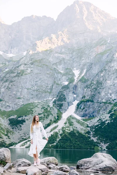Beautiful mountains and mountain lake. slender girl in white dre — 图库照片