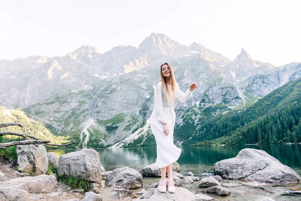 Belo sorriso de menina em vestido branco no fundo do moun — Fotografia de Stock