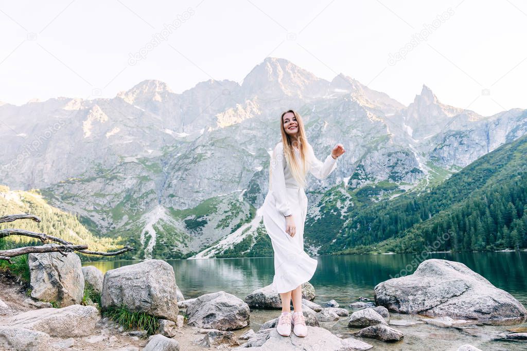 beautiful smile of girl in white dress on the background of moun