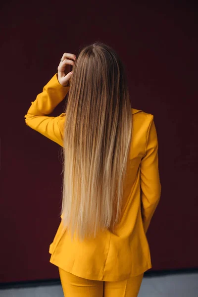 Back view on woman with long hair in yellow classic suit. close — 스톡 사진