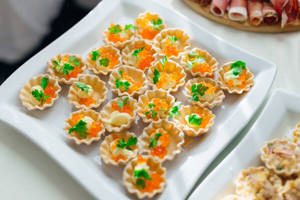 пирожные с икрой и маслом украшены листьями петрушки. топ
 