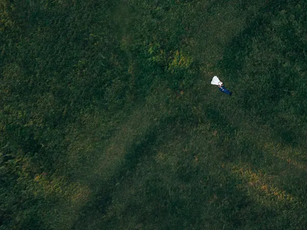 Vista do helicóptero em recém-casados estão deitados na grama. grande — Fotografia de Stock