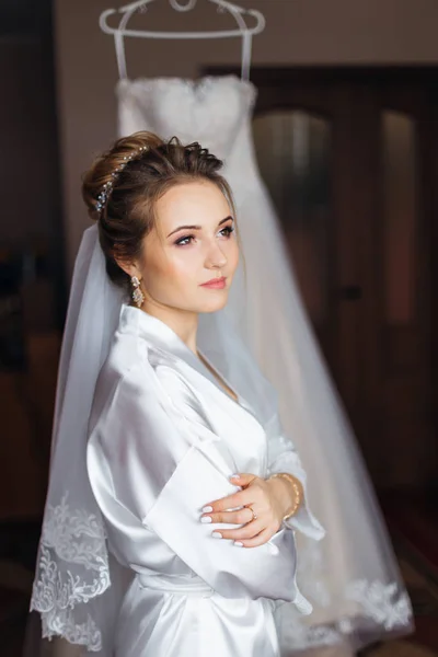 Невеста в белом халате с макияжем и свадебной вуали скрещенной рукой — стоковое фото