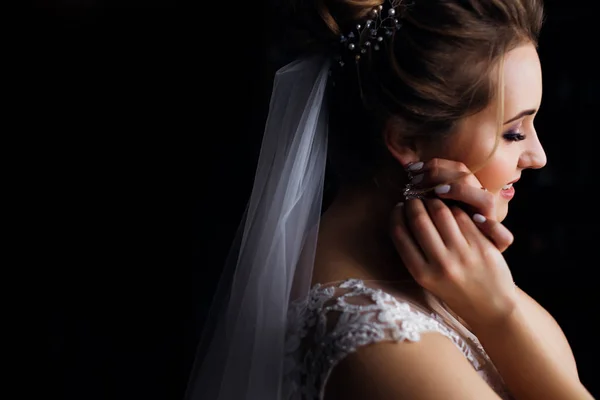 Noiva de perfil com véu de casamento e vestido branco. menina corrige e — Fotografia de Stock