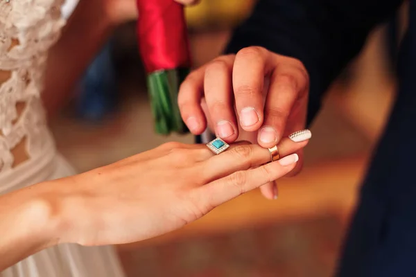 The groom and puts a wedding ring on the bride's finger at the w — ストック写真
