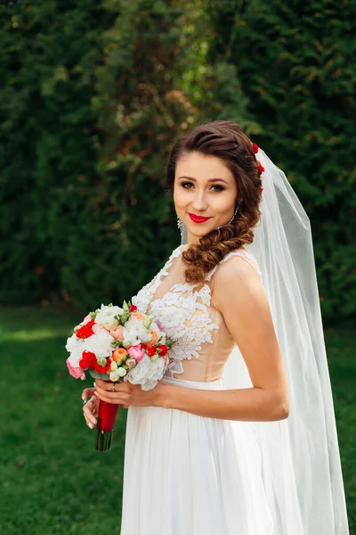 Noiva com buquê de casamento em vestido de noiva elegante olha para c — Fotografia de Stock