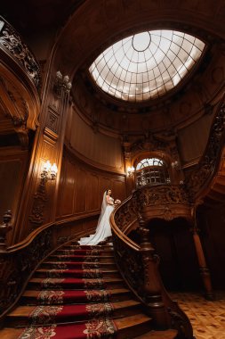bride in white wedding dress with wedding bouquet on elegant woo
